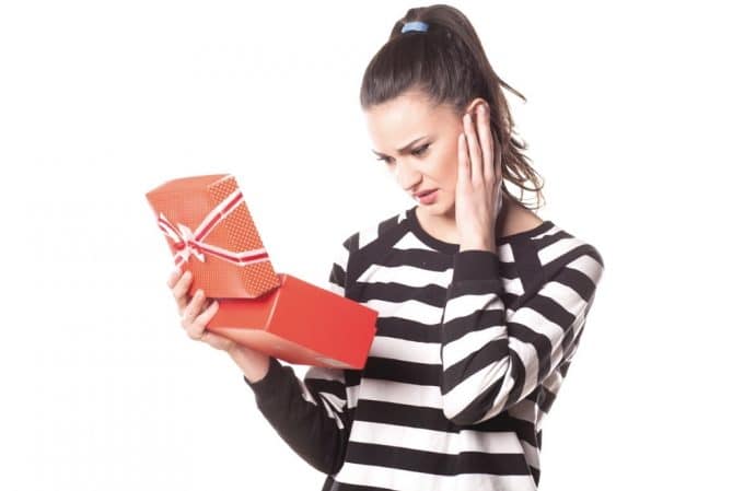 WHAT TO DO WITH UNWANTED GIFTS, HOW TO DEAL WITH UNWANTED GIFTS, WOMAN RECEIVING A GIFT SHE DOESN'T LIKE