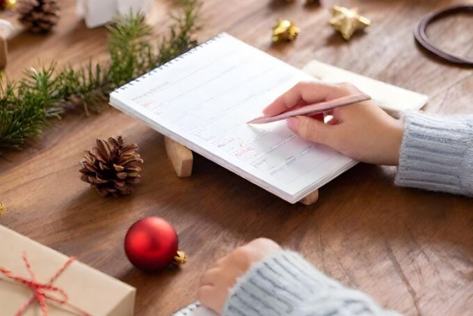 Woman writing out her Christmas planning list
